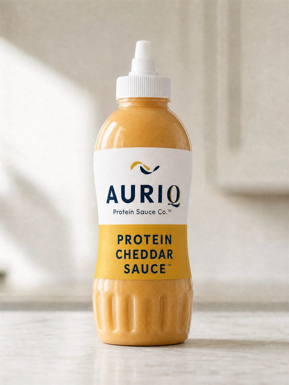 AURIQ Protein Cheddar Sauce squeeze bottle on a kitchen counter